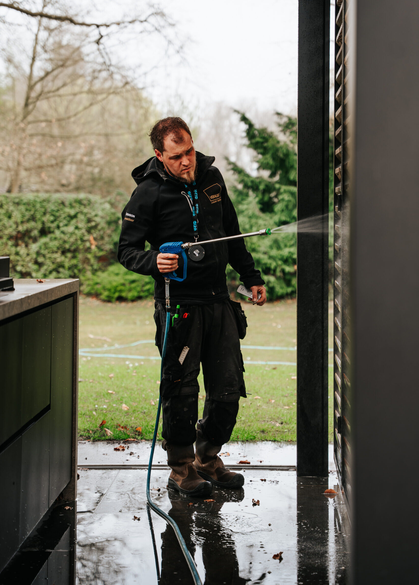 gespecialiseerde schoonmaker voert een reiniging uit met softwash